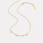 Heart initial necklace in 18K gold, flat lay
