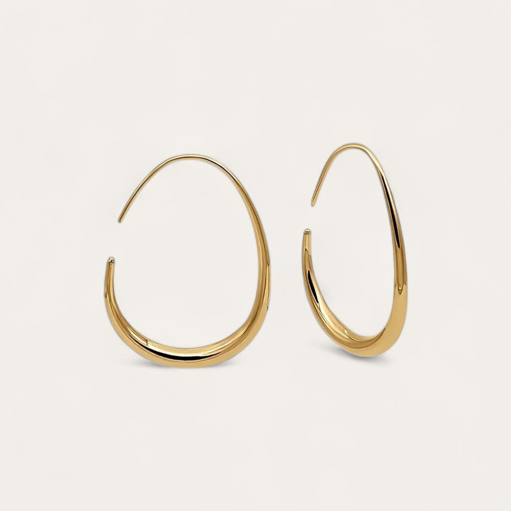 The pair of gold KOVA Hoops on a cream background, the teardrop taper visible