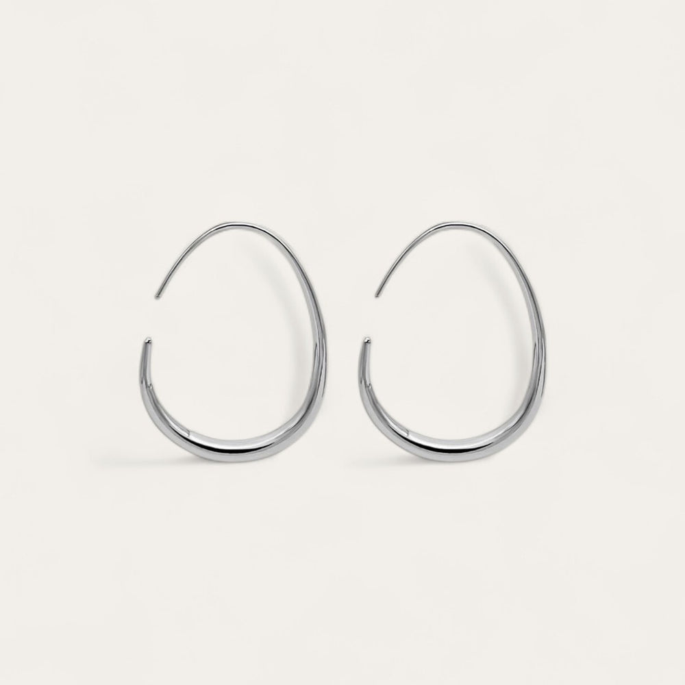 The pair of silver KOVA Hoops on a cream background, the teardrop taper visible