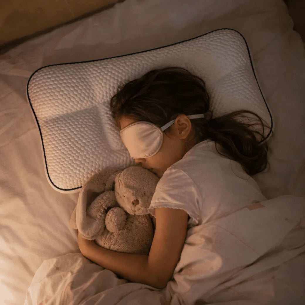 Child asleep with their stuffed animal on the Kovalya pillow